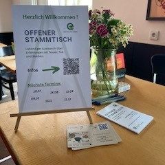 Begegnungen Tisch mit Plakat vom Stammtisch Astarix